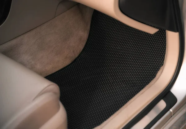 Car interior with honeycomb vinyl floor mat.
