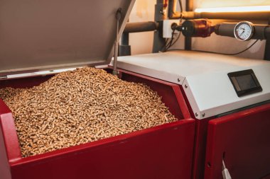 Wood pellets heating stove. Boiler room in private household working on alternative energy biofuel. Sustainable Future Concept