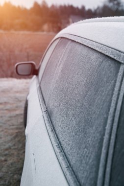 Frozen car on the outside parking. Transport in winter. Vehicle close-up with frozen windshield and windows.