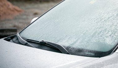 frozen windshield wiper. concept of dangerous driving during the winter season.