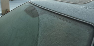 Clearing the snow from the car, after a heavy storm. Mechanical deicer tool.