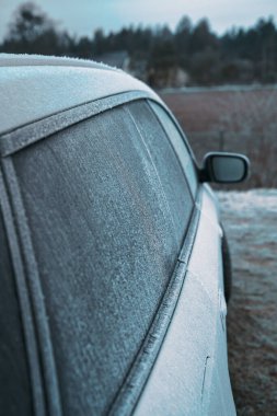 Frozen car on the outside parking. Transport in winter. Vehicle close-up with frozen windshield and windows.