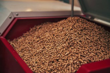 Close-up of a red color pellet oven in the household. Wooden pellet boiler room