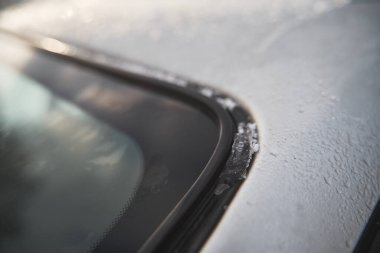 Wet car window. Vehicle glass covered with melted snow and water.