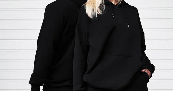 Man and woman wear black hoodie without a logo. Long sleeve dark sweatshirt mockup. Basic clothing sportswear.