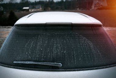car is covered with frost. cold morning with a vehicle parked outside during night