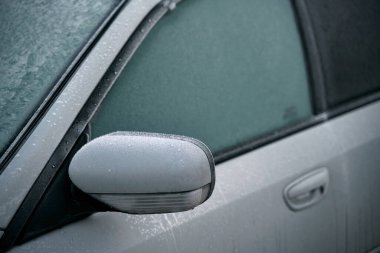 car is covered with frost. cold morning with a vehicle parked outside during night