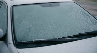 Frozen car on the outside parking. Transport in winter. Vehicle close-up with frozen windshield and windows.