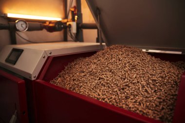 automatic pellet burner system. living house heating boiler system for winter season. concept of sustainability and alternative energy fuel