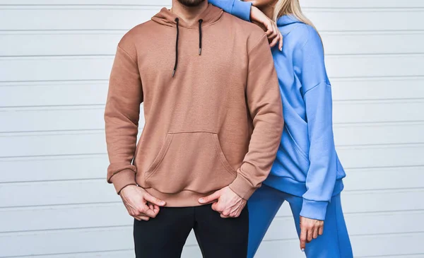 Basic clothing brand mockup. Design template for hoodie and casual sportswear. A woman and man wearing hoodies with no logo. Horizontal sweatshirt mock-up