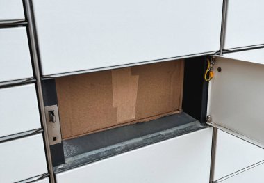 Cardboard box in a lockbox. Packed goods in parcel machine. Self service delivery and logistics for better future sustainability.