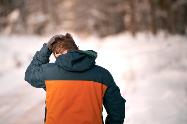 A person walks in a snow-covered forest on a sunny winter day. Hiking after snowstorm