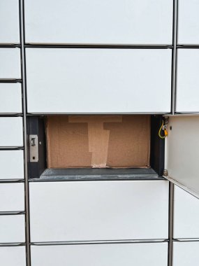 Cardboard box in a lockbox. Packed goods in parcel machine. Self service delivery and logistics for better future sustainability.