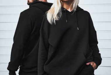 Basic clothing brand mockup. Design template for hoodie and casual sportswear. A woman and man wearing hoodies with no logo. Horizontal sweatshirt mock-up