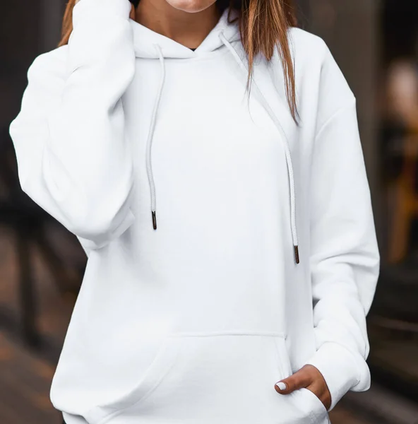 Design mock-up for clothing logo. Girl wears a white basic hoodie. No logo street wear brand design.