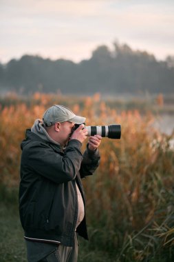 08.10.2022 Gdansk, Polonya. DSLR kamerasıyla vahşi hayatın fotoğrafını çeken bir adam..