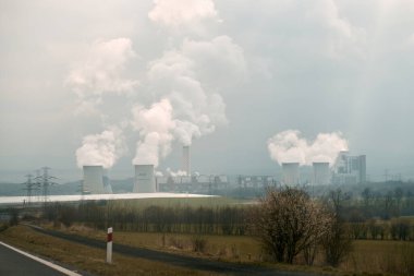 Bogatynia, Polonya, Avrupa - 8 Nisan 2023: Bogatynia 'daki Turow PGE maden ve enerji santrali. İçinden duman çıkan iki büyük beton soğutma kulesi. Kömür santrali.