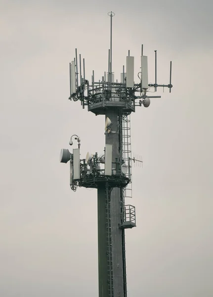 通信塔だ 5Gネットワーク ネットワーク接続ビジネスの背景 マスト及びマイクロ波無線リンクアンテナを有する異なる携帯電話 無線及びテレビ事業者の電気通信塔4G及び5Gフィーダー — ストック写真