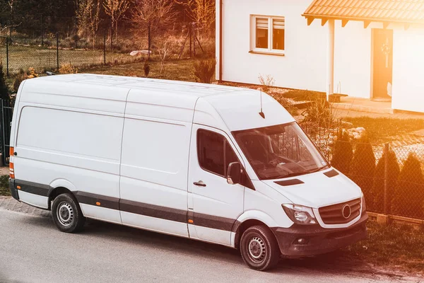 stock image Door-to-door delivery truck design mockup. Logistics concept. A white delivery van is parked on the side of the road.