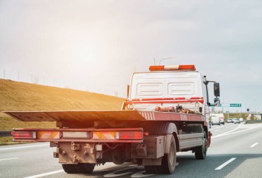 empty tow truck with drives down a highway clipart