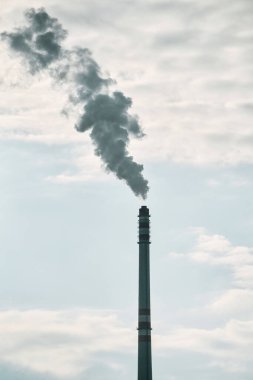 Mavi gökyüzüne karşı bacadan duman çıkıyor. Küresel ısınma ve endüstriyel etki kavramı.