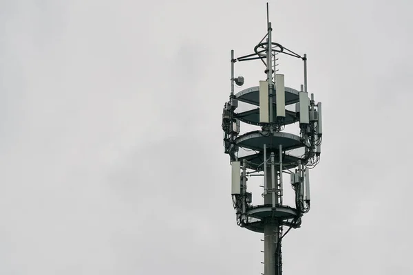 Macro Base Station. Telecommunication tower of 4G LTE Advanced and 5G cellular. 5G radio network telecommunication equipment with radio modules and smart antennas mounted on a metal against cloulds sky background.