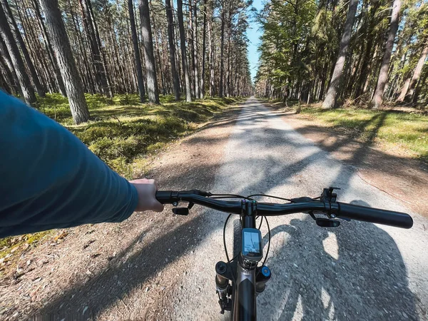 First-person riding bike in the woods. man cyclist rides in the forest on a bike. first-person view. travel concept