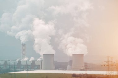 İçinden duman çıkan iki büyük beton soğutma kulesi. Kömür santrali.