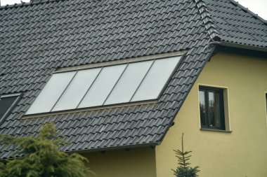 Kırmızı metal bir çatıda su güneş enerjisi toplayıcısı. Sıcak su için güneş ısısı ve güneş paneli.