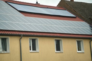 Kırmızı metal bir çatıda su güneş enerjisi toplayıcısı. Sıcak su için güneş ısısı ve güneş paneli.