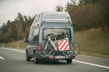 15.04.2023 Almanya, Avrupa Araba bisiklet taşıyor. Otoyol boyunca bisikletli bir taşıma aracı kullanılarak arkadan tutulan birkaç motosikletle seyahat eden bir araç. Bisikletli bir araç.