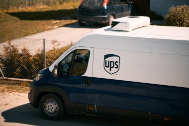 Polonya Avrupa 11.05.2023 UPS Sağlık Hizmetleri beyaz ve mavi minibüsü ülke tarafına park etti. Kırsal alanda tek aile evleri.