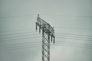 Dağlık vadide yüksek voltajlı elektrik direkleri. Alp manzarasında elektrik direği.