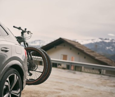 İki bisikleti olan bir araba. SUV bir askıda bisiklet taşıyor. Bagajda bisiklet var.