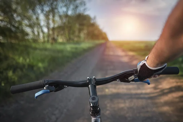 stock image Bike summer ride. First-Person View of a Cyclist Embracing the Outdoors. holding bike handlebar with one hand. summertime outdoor leisure sport activity. first-person view bicycle riding