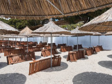 Yaz tatili geçmişi. Tropik bayram afişi. Tatil, güneşte rahatla. Mavi gökyüzüne karşı adanın güneşlik şemsiyesi.