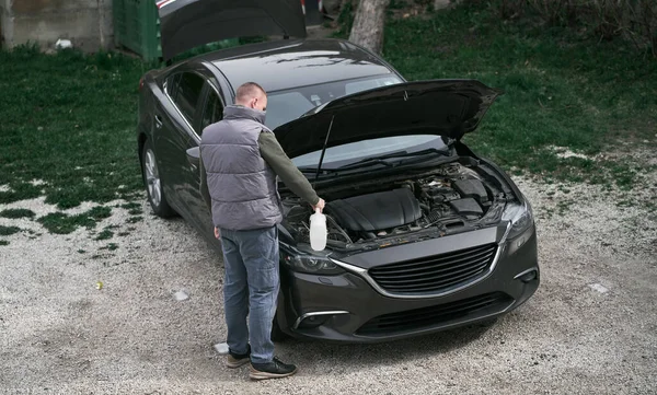 男が車のフードの前に立っている ポーチで車を修理する男 — ストック写真