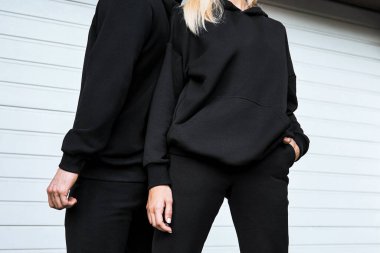 Süslü kapüşonlu model. Genç Çiftler İçin Moda Sonbahar Sokak Giyimi. Kadın ve erkek logosuz siyah kapüşonlu giyer. Temel spor giyim logosu yok. Uzun kollu kazak modeli.