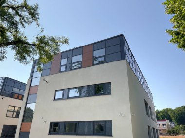 Çağdaş Düşük Katlı Ofis Binası Yaz Gökyüzünü Kucaklıyor. Polonya 'nın Banliyölerindeki Modern Mimari Mücevher