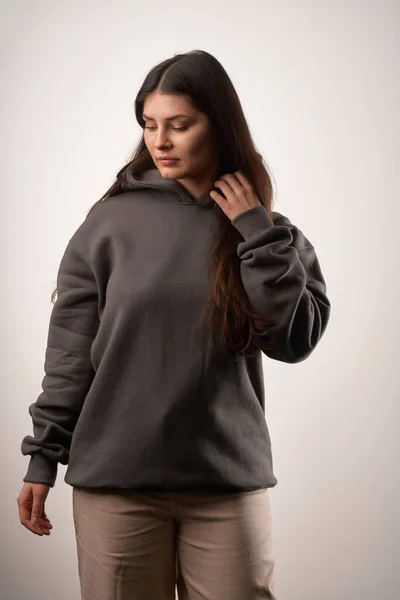 Woman Showcasing a Black Hoodie for Logo Branding. Streetwear clothing mock-up. Logo on shirt template copy space.
