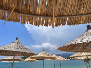 Tropik Kaçış. Güneş Adası 'nın güneşlik şemsiyesinin altında, mavi gökyüzüne karşı gevşeyin ve rahatlayın. Tropik cennet konsepti.