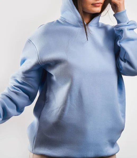 Woman Showcasing a blue Hoodie for Logo Branding. Streetwear clothing mock-up. Logo on shirt template copy space.
