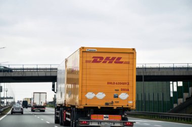 Almanya Avrupa - 15.04.2023 DHL kamyon otoyolda. Uluslararası kurye, paket ve ekspres posta servisi DHL 'ye ait kamyon