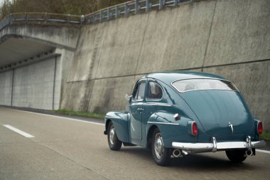Klasik Avrupa Güzeli. Blue Oldtimer Coupe Speeding Umumi Otoyol 'da. Sokaklarda eski bir Avrupalı model..