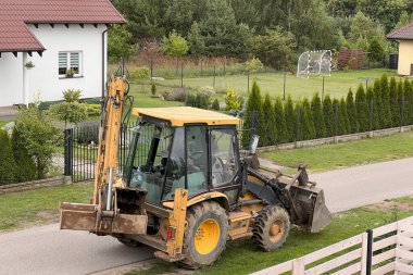 Sarı traktör. Mini kazıcı buldozer. Kırsal bölgedeki toprak taşıma şirketi..