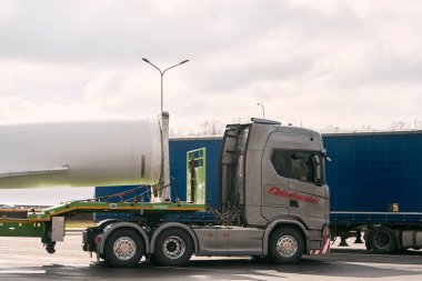 08.04.2023 Polonya, Avrupa. Karavanının arkasında rüzgar türbini taşıyan büyük bir tır. Convoi İstisnai çevirisi: 