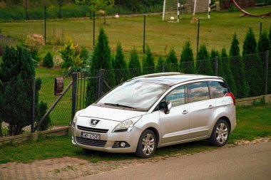 03.07.2023. Polonya, Avrupa. Kırsal yolda Fransız bir minivan ailesi var. Peugeot 5008 2009 - 2016 MPV Sokakta