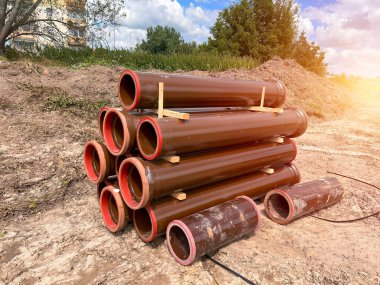 İnşaat alanında kullanılan büyük kahverengi boruların arka planı. Yerde bir sürü büyük boru var. Lağım inşaatı devam ediyor. boru arkaplanı