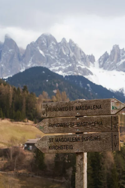 Wooden signpost in front of rough Alpine mountain range in the background. Hiking Adventures in the Majestic Dolomites. Exploring Nature\'s Beauty
