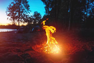Deniz kenarında kırsal bir akşam. Riverside Kampında Şenlik Ateşi Macerası